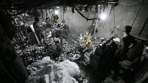 DHAKA, BANGLADESH - NOVEMBER 10, 2020: An industrial metal steel factory with people working in non compliance circumstances in a sweatshop to produce metal pots and pans