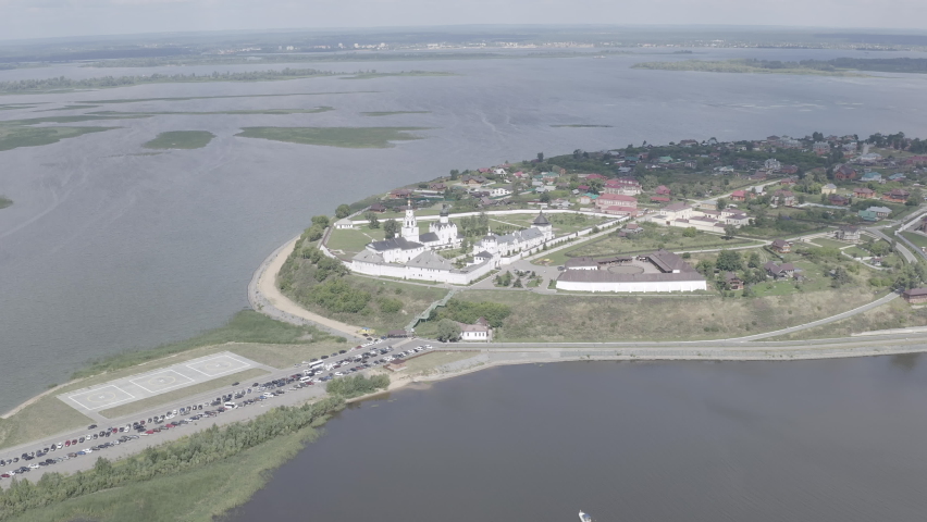 Sviyazhsk, Russia. The Assumption Cathedral and Monastery complex dominates this aerial view of the island-town, its white-walled fortress perimeter and clustered onion domes standing sharply against the surrounding waters of the Volga and Sviyaga rivers. The monastery