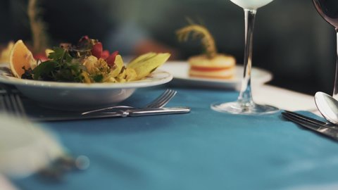 Close-up shot of the food served on the plate on the dining table. waiter serving dish. Close up shot of waiter hand putting a plate with steak. luxury restaurant.4K.