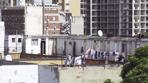 Guateng / South Africa - 02 13 2017: Teens hanging clothes and playing on the rooftops of apartment buildings in Johannesburg South Africa. Static. Long shot.