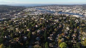 Aerial / drone footage of the Olympic Mountains and affluent neighborhoods uptown in Seattle, Washington