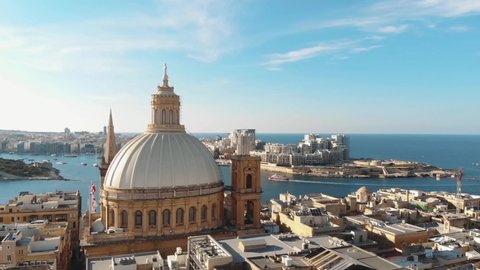 Carmelite Church dome with cityscape in background. Valletta, Malta. Aerial circling shot