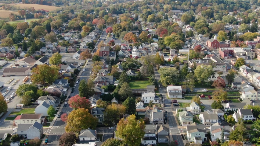 Establishing shot of small town in America. Homes in quiet quaint residential housing district. Aerial drone view. Royalty-Free Stock Footage #1062590035