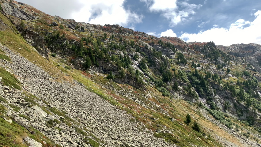 Pan right on la thuile filming the Lac du Glacier and the mountains with grazing sheep