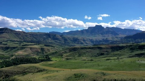 Time-lapse of lush green valley and blue mountains with fasting clouds over Drakensberg Mountains, South Africa