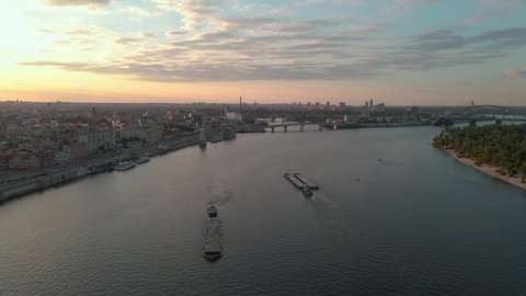 Aerial shot of ships sailing on the Dnipro river near Kiev with the sunset behind.