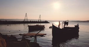 Fishing boat on sea shore during sunset over Varna city