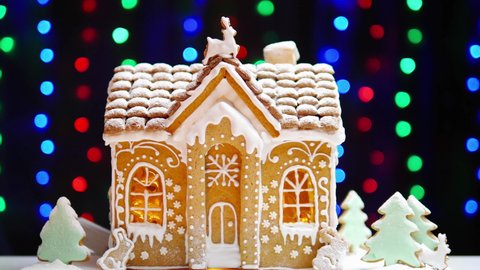 Handmade gingerbread Christmas house on a background of blinking lights. Concept New Year and Christmas