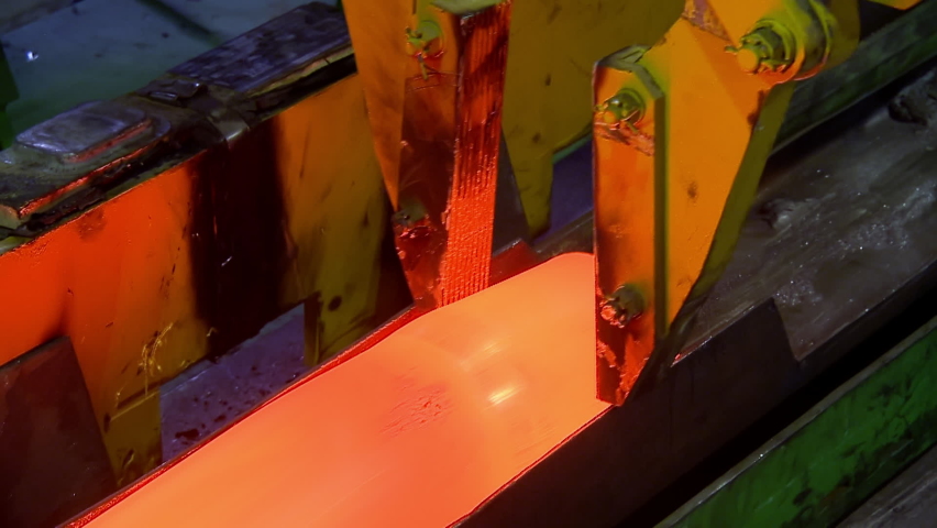 Hot orange Copper Bar Transportation on Industrial Line at Factory of Non-Ferrous Metal Production plant. Conveyor crane at pipe production factory. Heavy industry. Metallurgy. Royalty-Free Stock Footage #1062596032