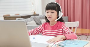 asian girl is using protractor and learning math online through laptop with headset at home