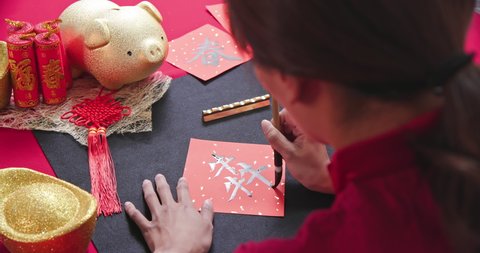 back view video of asian woman write spring festival couplet to celebrate Chinese new year with word meaning Ox