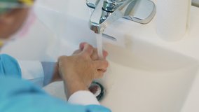 Close up video of male washing hands in a sink. Concept of health, cleaning and preventing germs and coronavirus from contacting hands.