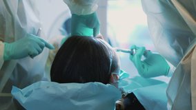 4k video of male patient lying on dentist chair while professional dentists making dental surgery.