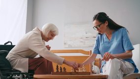 side view of elderly woman playing chess with nurse
