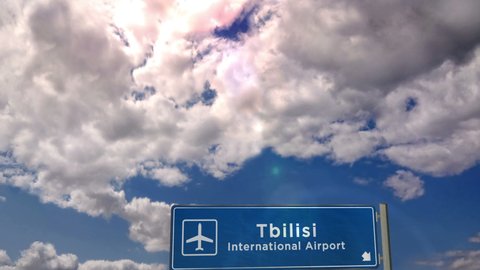 Jet plane landing in Tbilisi, Georgia. City arrival with airport direction sign. Travel, business, tourism and transport concept. 3D rendering animation.