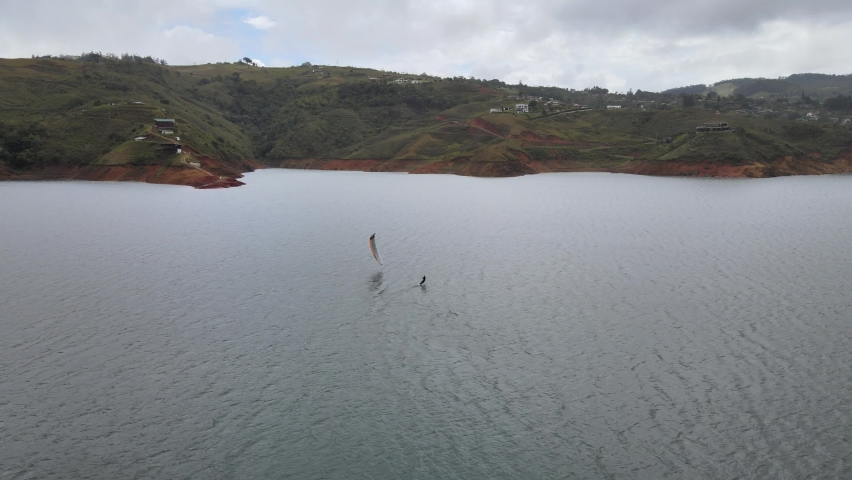 aerial video of young man practicing kite foil at lake calima, colombia