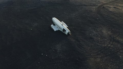 Drone Flight Arc Shot Over Abandoned Plane Wreck On Black Sand At Sunset, Iceland