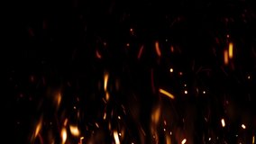 Bright burning hot bonfire sparks, embers rising from the fire on dark background. Black night sky. Realistic fire flame close up video. Overlay, screen mode animation. Slow motion campfire 4K footage