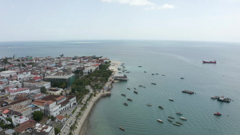 
Aerial view Zanzibar Tanzania. A drone flies over the shoreline that separates old houses and streets with a sandy beach and the Indian Ocean in which boats stand. Beautiful landscape drone video.