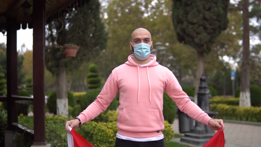 man in mask holding flag of china 