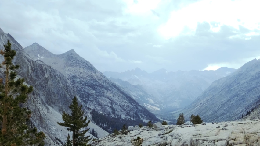 Stunning pan of mountain range canyon along the Sierra Nevadas with cloudy skies (60 fps slowed to 30 fps)