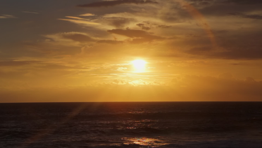 Golden sunset over Reunion Island seen from Grand Anse beach