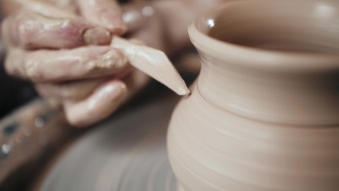Man potter working on potters wheel making ceramic pot from clay in pottery workshop. Traditional arabian art concept, creative workshop and masterclass.