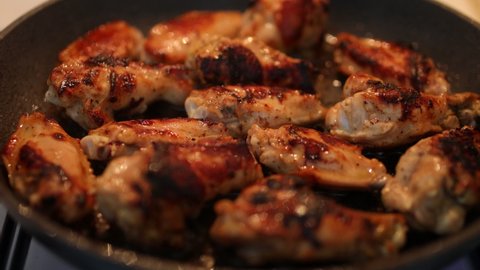 Close-up of chicken legs fried in a pan. chicken legs in spices are fried in a pan. Fatty fried chicken fried with spices in a pan, junk food. Vascular clogging with cholesterol, atherosclerosis.