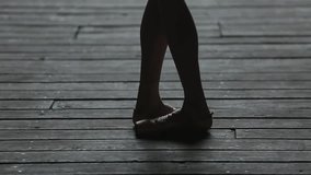 Video footage graceful ballerina dancing feet on the floor in backlit.