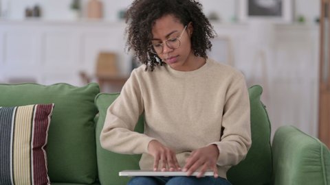 African Woman Coming Back Opening Laptop from Sofa 