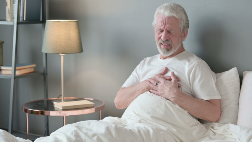 Old Man having with Chest Pain Sitting in Bed  | Shutterstock HD Video #1062632455