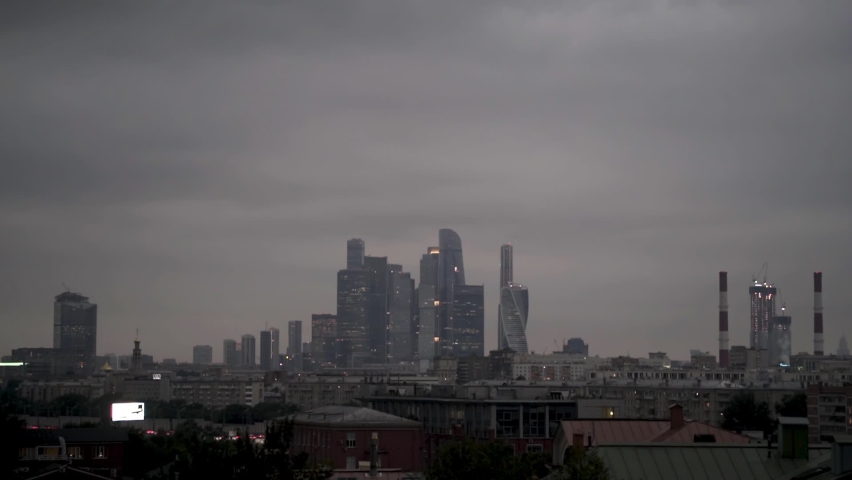 Skyscrapers of Moscow-City late in the evening, Russia. Action. Business district in Moscow centre, panorama of modern buildings under heavy grey clouds and fog.
