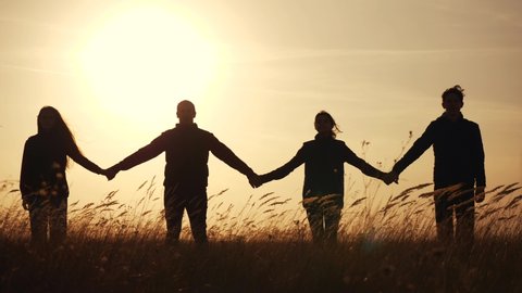 teamwork. team community hold hands together silhouette at sunset unity. group of people hands. teamwork a workers carry out one mission go the goal business. team in the company working partnership