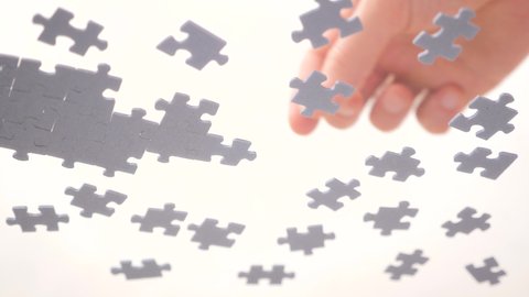 Close Up Human Hands Assembling Jigsaw Puzzle. Leisure Activity. Playing Calm Board Game. Pastime, a Hobby. Unfinished Jigsaw Puzzle. Finding a Solution for Business. Learning Concept. Bottom View