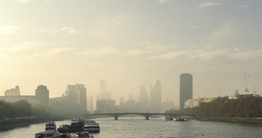 Timelapse of iconic London City Skyline and River Thames, time lapse of clouds moving at sunset over Lambeth Bridge with skyscrapers and offices, shot in Coronavirus Covid-19 lockdown in England, UK