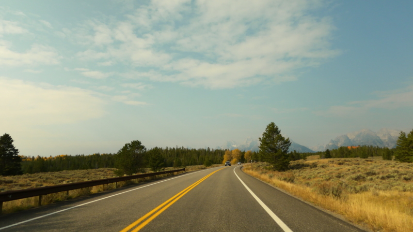 Grant Teton Wyoming mountains forest drive POV 4K. Grand Teton National Park. Destination for mountaineering, hiking, fishing and recreation. Geography, geology, environment.