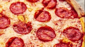 Pizza with pepperoni filmed in close up video.Delicious Italian fast food delivered for dinner in cardboard box,filmed in closeup footage clip