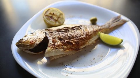 Whole sea bass fish cooked on grill in seafood restaurant 