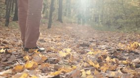 Feet walking on the ground slow-motion video . autumn yellow foliage. Men's feet in classic shoes in a city Park. High quality FullHD footage