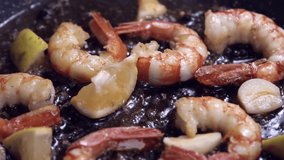 large king prawns are fried in a pan in olive oil with garlic and spices. The video rotation