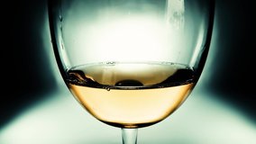 Creative macro slow motion video of white wine pouring into a glass. Glass with pouring white wine close-up. Old retro grunge vintage style.