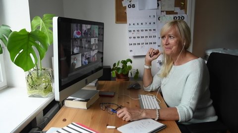 Smiling mature woman having video call via computer in the home office. Online team meeting video conference calling from home. Attractive Businesswoman Telework. Business video conferencing. Video de stock