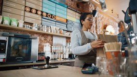 Friendly Latin Barista Serves Order to a Food Delivery Courier Picking Up Two Take Away Coffees and Pastries from a Cafe Restaurant. Delivery Guy Puts Food in His Hot Thermal Insulated Bag. - Powered by Shutterstock - Get 15% off with code: PIKWIZARD15