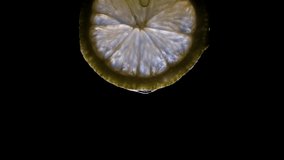 A pulsing light lights up a lemon slice isolated on a black background. - Powered by Shutterstock - Get 15% off with code: PIKWIZARD15