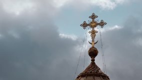 Christian cross on the dome of an Orthodox church against a cloudy sky