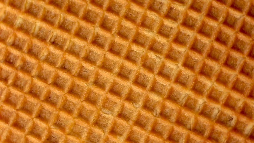Close-up waffles move in a circular rotation. Texture of waffle cone background | Shutterstock HD Video #1062673603