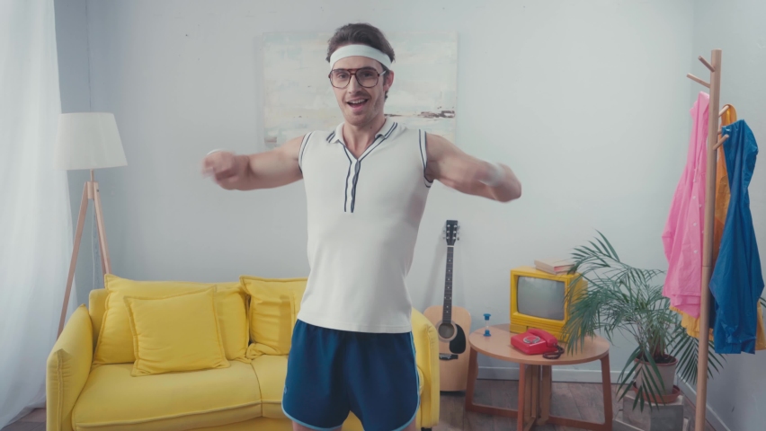 Energetic sportsman warming up in living room, retro sport concept