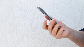 Side view. Hand of woman using smartphone on white background, typing message, swiping and liking. Close-up of women hand
