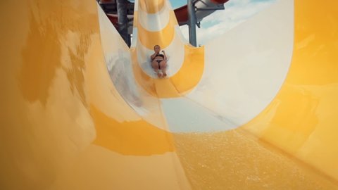 Summer Vacation Enjoying On Waterslide.Woman Having Fun On Water Slides Aqua Park Glides.Funny Ride On Water Slide Pool In Water Park. Sliding Down In Waterpark.Happy Cheerful Female On Holiday Resort