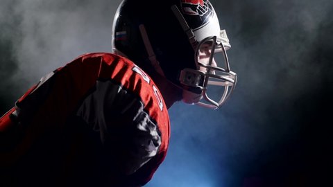 Usa team game and extreme sport spirit concept. Portrait of determined professional American football player in helmet in bright stadium illumination lights ready for game. Confident man in uniform.
